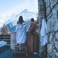 Couple au bord d'un spa regardant la montagne enneigée 