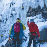 Personnes de dos qui s'apprêtent à escalader une cascade de glace